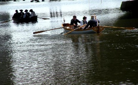 The two boats loaded with pirates wait under the bridge