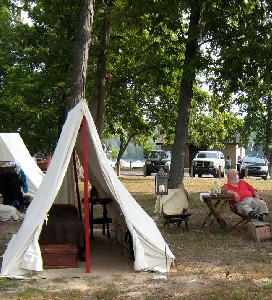 Guy relaxing in a lounger near his tent