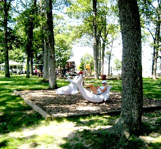 Woman laying on a concrete dolphin in the park