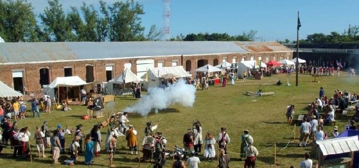 The pirates fire their cannon at the British defenders