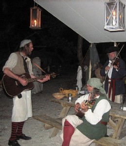 Greg Hudson and Captain Jim playing guitars with Mark Gist accompanying on the fiddle