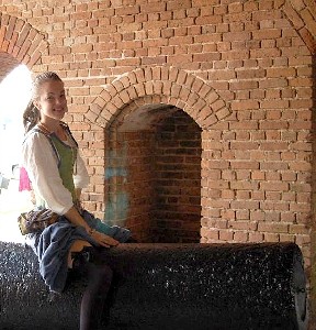 Mae straddling a large cannon