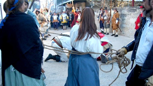 The buccaneers scramble in the street to pick up the dropped loot